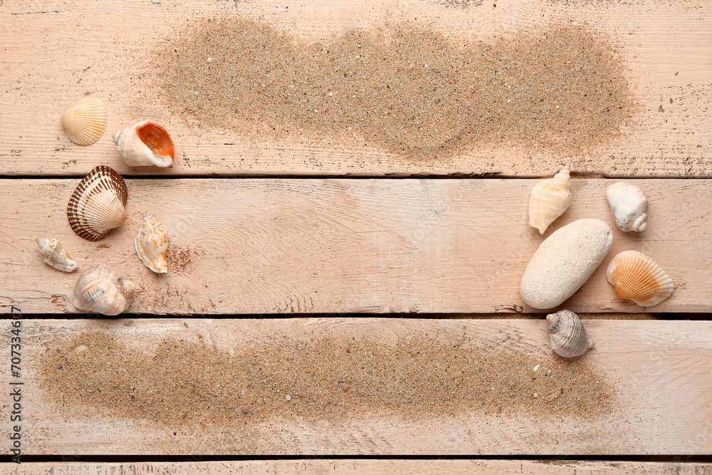 Wall mural sand with shells and stone on beige wooden background