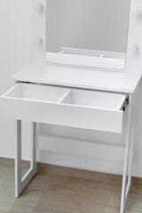 Close-up of a white dressing table with an open drawer.