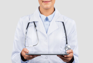 Close-up of a confident Caucasian millennial doctor's hands holding a digital tablet