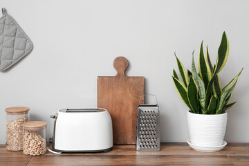 Wooden kitchen countertop with utensils, toaster and houseplant