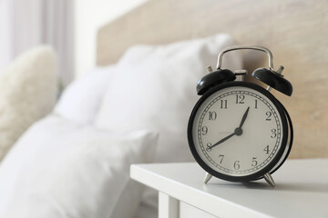 Alarm clock on bedside table in bedroom, closeup