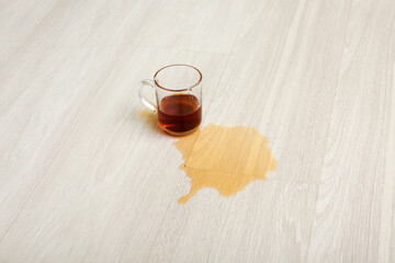 Wooden laminate floor with cup and spilled tea