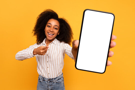 Happy Black Woman Presenting Smartphone Screen On Yellow Background