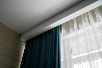 A sleek, contemporary room features a cornice discreetly concealing modern curtains, with natural...