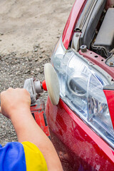 polishing headlights close-up on a red passenger car