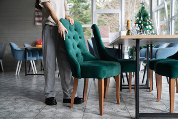 A person is shown firmly gripping a chair, in the process of moving it.