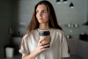 A woman enjoys a moment of quiet contemplation with her coffee in the modern, minimalist ambiance of a coffee shop.