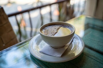 large coffee or cup of joe with milk at an outdoor restaurant for breakfast