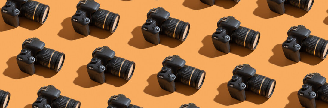 Pattern from many photo cameras on colored background. World Photography Day concept - Powered by Adobe