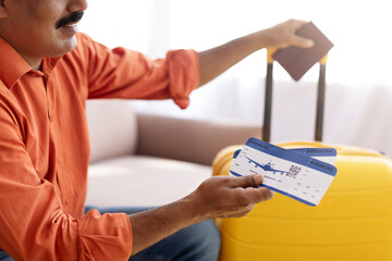 Cropped of eastern man showing flight tickets