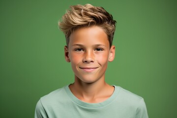 portrait of smiling boy with short hairstyle over green background. - obrazy, fototapety, plakaty