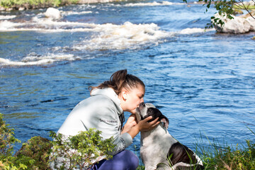 A woman on a walk with a dog against the background of a river threshold. Republic of Karelia wild...