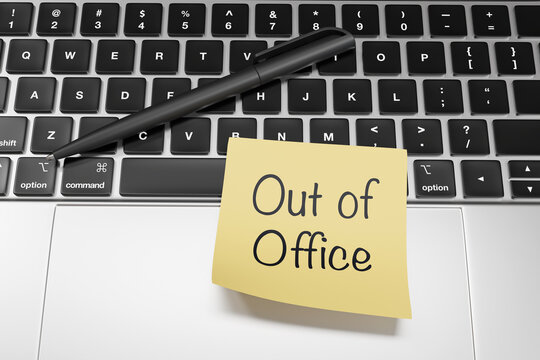 Yellow sticky note written with the message Out of Office stuck on a silver laptop. Illustration of the concept of annual leave and public holidays of employees