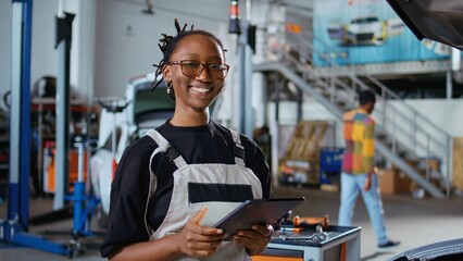 Certified repairman in auto repair shop showing customer what needs to be changed on her car for it...