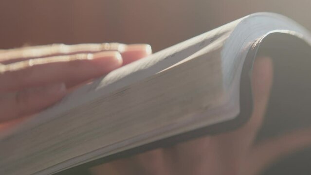 Macro shot of hands studying scripture and holding the Bible 