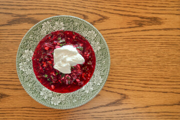 A traditional dish of Ukrainian cuisine - borsch. Soup with beets, meat, potatoes and beans. Served with sour cream and garlic. Close-up