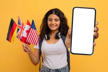 Cheerful young indian woman student with many different flags, smartphone