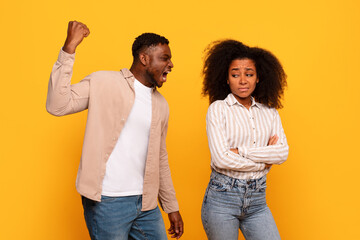 Angry black man yelling, woman upset on yellow backdrop