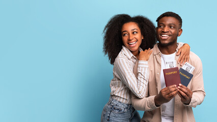 Excited african american couple with passports ready to travel, free space