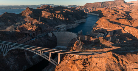 Hoover Dam on the Colorado River straddling Nevada and Arizona at dawn from above. Aerial view of Hoover Dam and the Colorado River Bridge