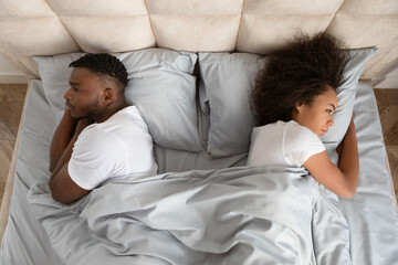 Black Couple Turning Backs To Each Other Lying In Bed
