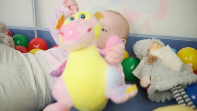 Cute baby girl lying on the floor with toys in her room