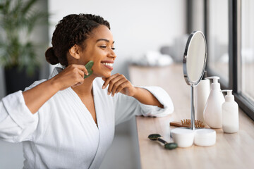 Beauty Tools. Young Black Woman Making Face Massage With Gua Sha Scraper