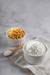 Maize starch. Cornstarch in the bowl and corn kernels.