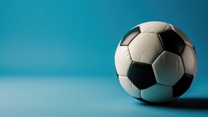 Fototapeta na wymiar Classic black and white soccer ball on a blue background