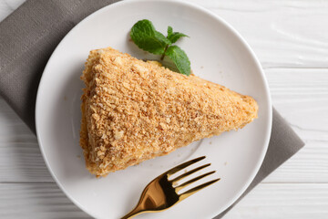Piece of delicious Napoleon cake served on table, top view