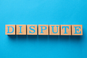 Word Dispute made with wooden cubes on light blue background, top view