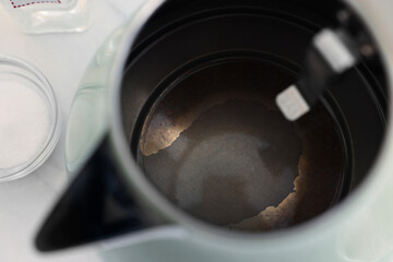 Electric kettle with limescale on table, above view