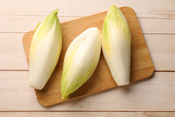 Raw ripe chicories on wooden table, top view