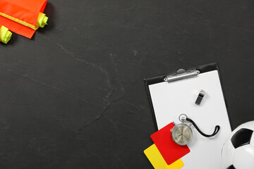 Different referee equipment on black table, flat lay. Space for text