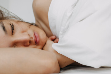 Fototapeta na wymiar Asian woman sleeping and wake up late in very comfort morning.