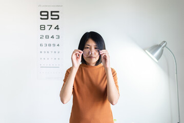 Asian women holding a new glasses myopia pink color at optical shop