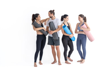 Fototapeta na wymiar Group of happy sporty girls and guy wearing body stylish sportswear holding personal carpets leaned on a white background. waiting for yoga class or body weight class. healthy lifestyle and wellness