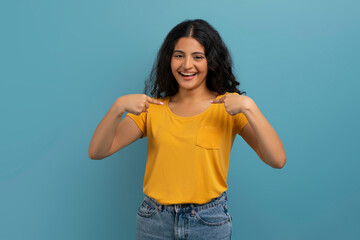 Overjoyed young indian woman pointing at herself and laughing