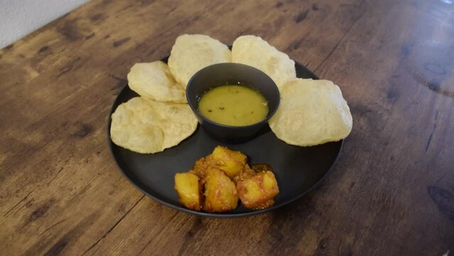 Bengali traditonal dish Luchi with Aloor Dum and Cholar Daal. Luchi is deep fried bread with potato curry and yellow lentil