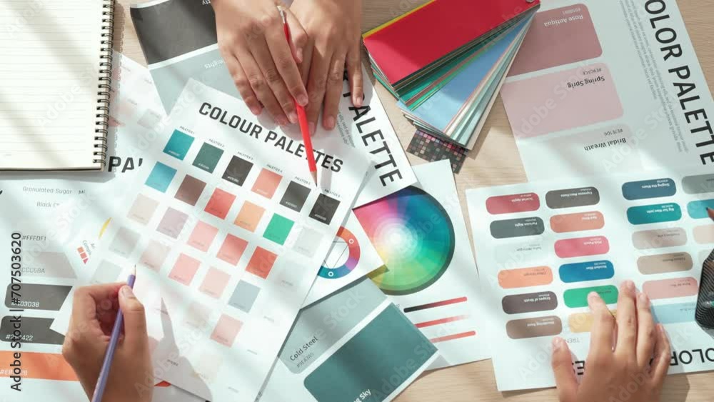 Aufkleber top view hand closeup on workspace table of two designer choosing color for graphic design working o