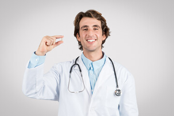 Doctor man holding pill and smiling, healthcare concept