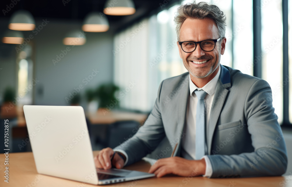 Wall mural Man Sitting at Table With Laptop for Work