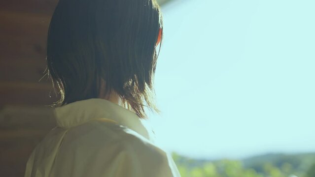 テラスから屋外を見つめる女性