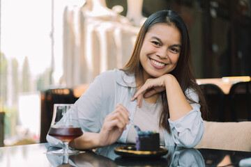 Young woman is happy and enjoys eating sweets and coffee at a cafe.