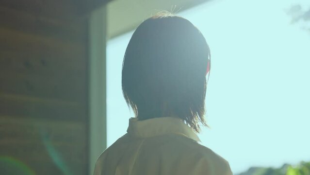 テラスから屋外を見つめる女性