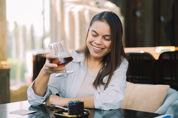 Young woman is happy and enjoys eating sweets and coffee at a cafe.