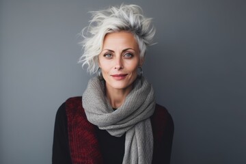 Portrait of a beautiful middle aged woman with short blond hair and gray scarf - obrazy, fototapety, plakaty