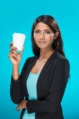 Indian woman holding a takeaway coffee cup on blue background