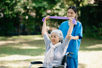 Asian physiotherapist helping elderly woman patient stretching arm during exercise correct with...