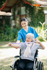 Asian physiotherapist helping elderly woman patient stretching arm during exercise correct with...